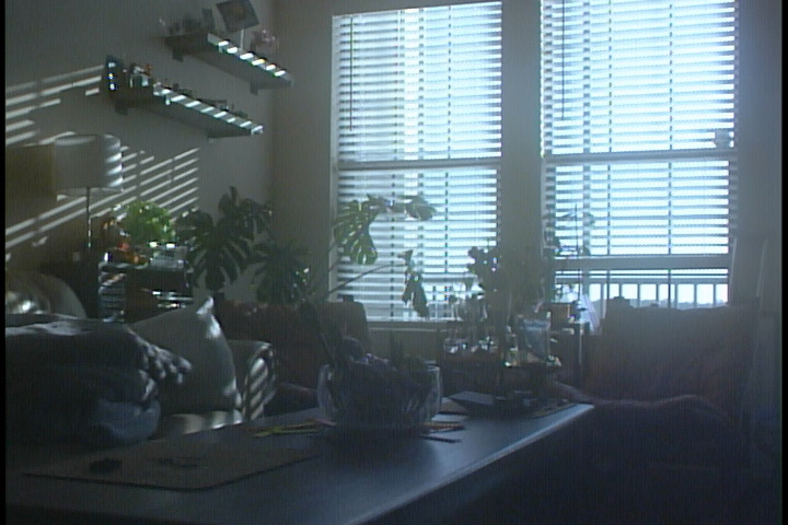 A screenshot of a dimly lit room with bright windows captured over composite